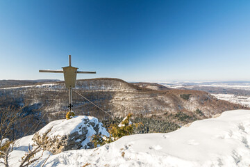 Summit cross on a mountain peak in a beautiful winter landscape in the Swabian Alps