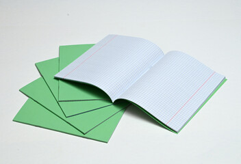 A stack of notebooks on a white background. Image with selective focus.