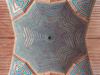 Beautiful red brick and blue tile star shaped geometric design on inner cupola at ancient Shah Jahan mosque in Thatta, Sindh, Pakistan