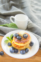 A healthy breakfast of pancakes, berries, butter, and honey