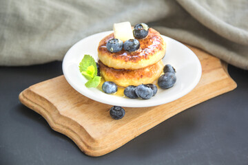 A healthy breakfast of pancakes, berries, butter, and honey