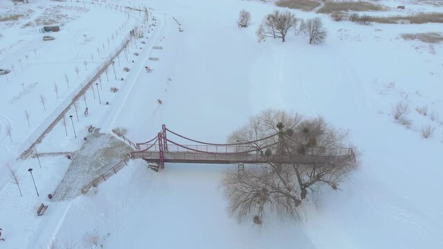 Bridge in winter drone aerial establishing shot janitors remove snow push in forward camera movement Irpin Ukraine