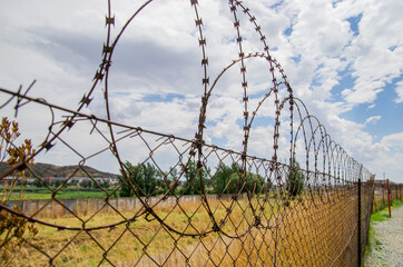 Close up view of barbed wire on the fence. Protection of the property. Protective fence.