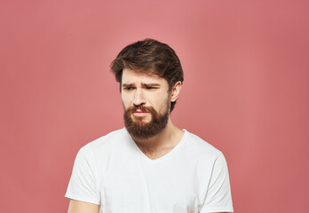 Obraz premium A man in a white T-shirt with a beard on a pink background Copy Space