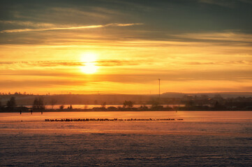 Naklejka premium Romantischer Sonnenuntergang über dem zugefrorenen Süßen See mit Blick auf Aseleben