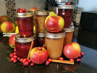 Apple Cranberry Sauce Fruit with Cinnamon  sticks and jars of sauce in kitchen