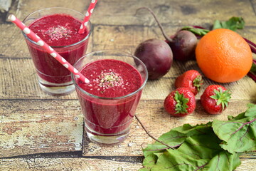 Healthy smoothie made from beetroot, strawberry, orange, beetroot leaves and hemp seeds