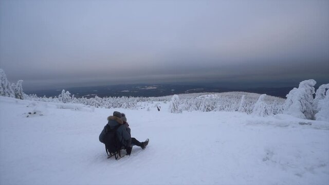 A couple sledding in winter in Brocken Harz Germany