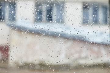 Rain drops on the window. Abstract city background with old home and window