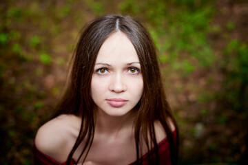 Beautiful young brunette woman with long hair in a forest pines and firs on a summer day