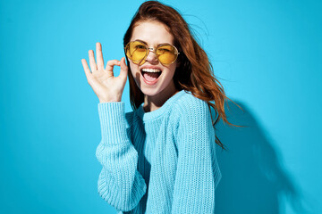 emotional woman with glasses and blue sweater lifestyle casual wear blue background