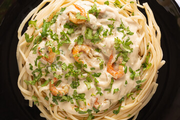 Pasta with shrimps in a creamy sauce, top view