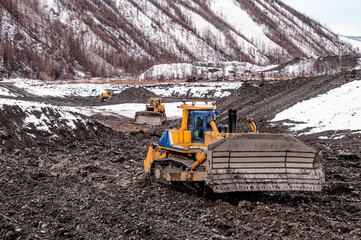 Bulldozer in  process of working in an industrial mountain area