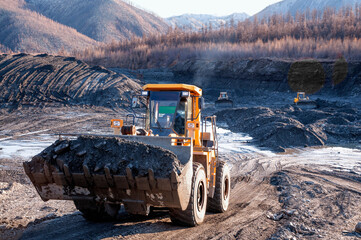 Wheel loader in the process of working in an industrial mountainous area e / Mining