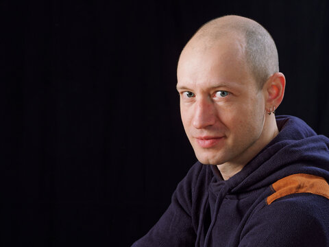 portrait of a bald man on a black background