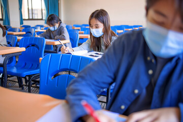Group of students wearing protection masks and studying in classroom
