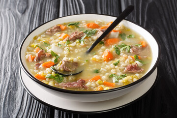 Scotch broth is a traditional hearty Scottish soup  closeup in the plate on the table. Horizontal