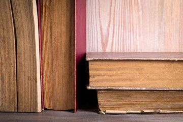 Stack of old, antique books. Wooden shelf
