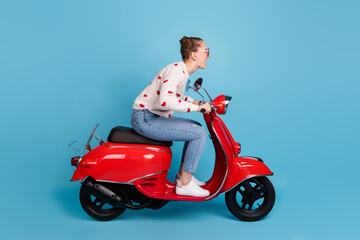Fototapeta na wymiar Full size profile side photo of charming excited young woman ride motorcycle on road isolated on blue color background