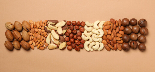 Set of different nuts on light beige background, top view