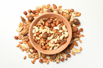 Wooden bowl with different tasty nuts on white background
