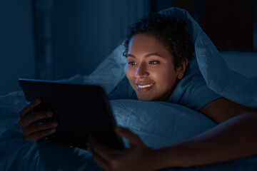 technology, internet, communication and people concept - happy smiling young african american woman...