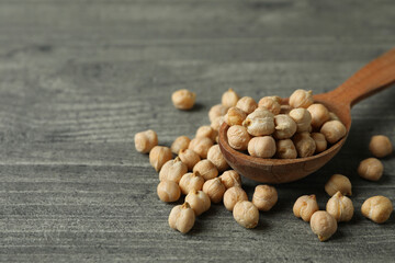Spoon with fresh chickpea on gray textured background