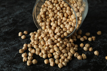 Glass jar with chickpea on black smokey table