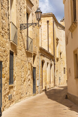 Italy, Apulia, Province of Lecce, Lecce. Stone buildings on a narrow street.