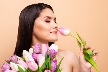 Profile side photo of happy nice young woman smell flower tulip healthcare isolated on pastel beige color background
