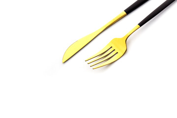Golden fork and knife close-up on white background. Flatware for food. Kitchen utensils.