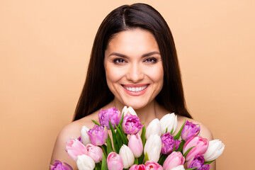 Photo of charming nice pretty happy woman hold flowers flawless skin isolated on beige color background