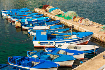 Fototapeta na wymiar Italy, Apulia, Province of Lecce, Gallipoli. Fishing boats tied up to piers in the Old City.