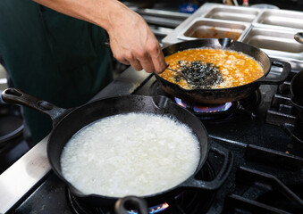 chef preparando dos risotos en cocina caliente