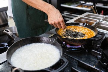 chef preparando dos risotos en cocina caliente - obrazy, fototapety, plakaty