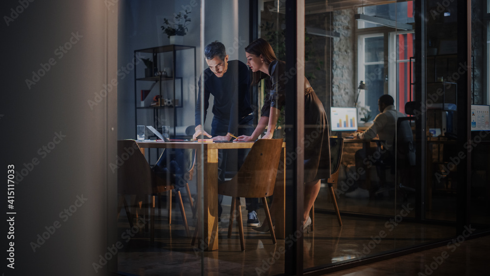 Poster two young and successful colleagues have a conversation in a meeting room behind glass walls in an a