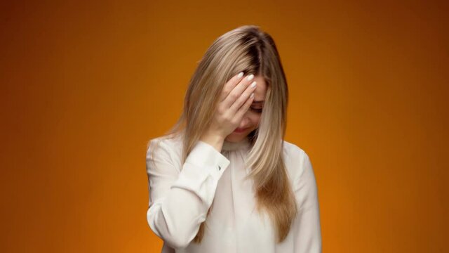 Upset woman slapping hand on face, feeling helpless