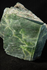Vertical shot of a green Jade mineral isolated on a black background