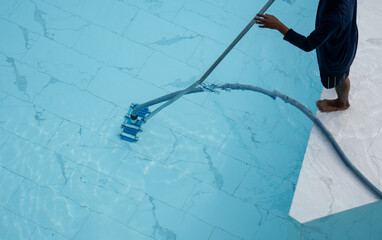Man is cleaning service and maintenance of the pool. Swimming pool cleaning.