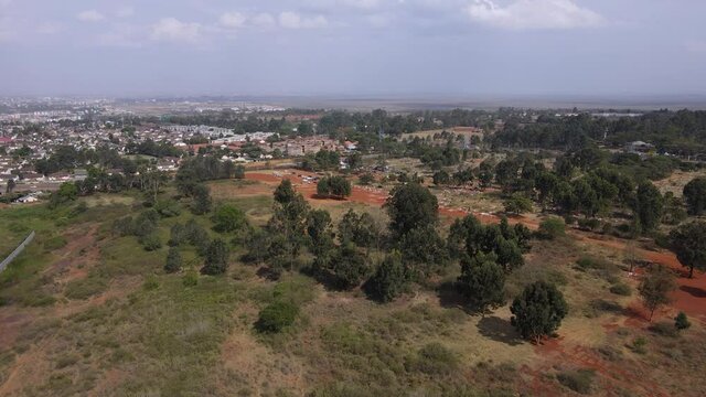 Suburbs of Nairobi and Langata Cemetery on sunny day, aerial drone shot