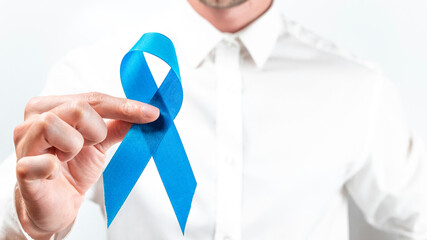 Prostate care. Awareness prostate of men health in November. Hipster men in bright shirt with blue ribbon in hands on white background. World cancer day and world diabetes day concept.