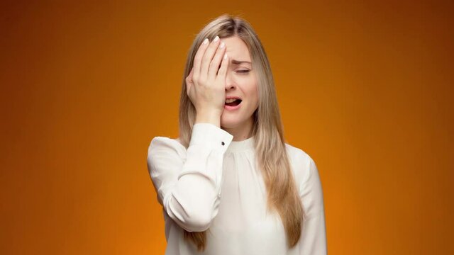 Upset woman slapping hand on face, feeling helpless