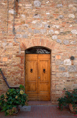 Fototapeta na wymiar Sienna, Tuscany, Italy - Wooden doors in a brick and stone building.