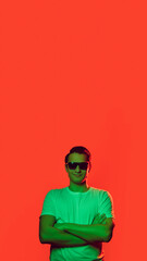 Flyer. Caucasian man's portrait isolated on red studio background in multicolored neon light. Beautiful male model. Concept of human emotions, facial expression, sales, ad, fashion. Copyspace.