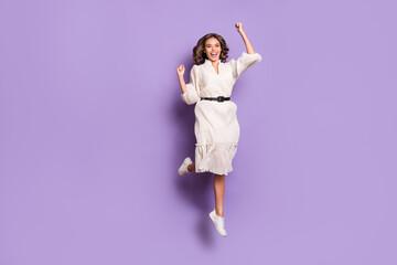 Full length body size photo of girl smiling jumping high gesturing like winner isolated on pastel purple color background