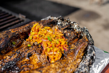 pescado zarandeado a las brasas de la parrilla con picadillo de chiles compartiendo en familia mesa...
