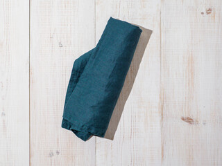 Linen kitchen towel or textile napkin on white wooden background.