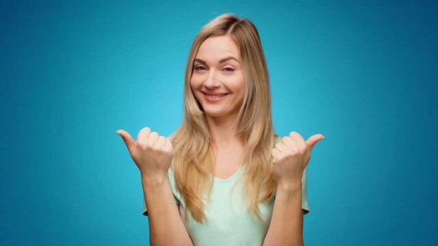 Young woman showing gesture of wasting money against blue background, materialist, shopping concept