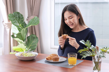 Obraz na płótnie Canvas Cheerful young Asian woman happy eating healthy food .