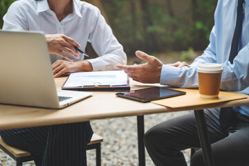 Business team discuss and collaborating on project during meeting in outdoor cafe.